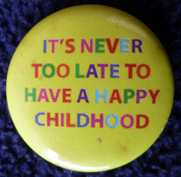Badge with the words 'It's never too late to have a happy childhood'